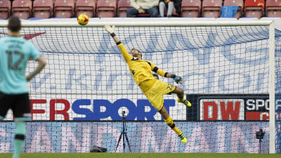 Wigan-målvakten Jussi Jääskeläinen räddar Derby-spelaren Derby Johnsons skott.