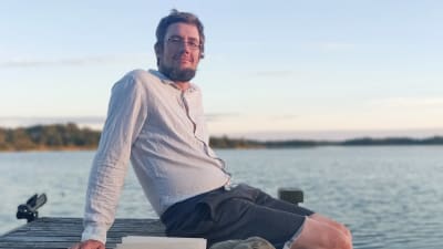 Fredrik Sonck sitter på en somrig brygga 