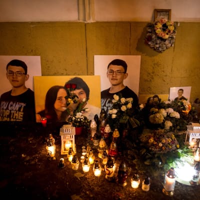 på bilden syns ljus, blommor och fotografier för att hedra journalisten Jan Kuciaks minne.