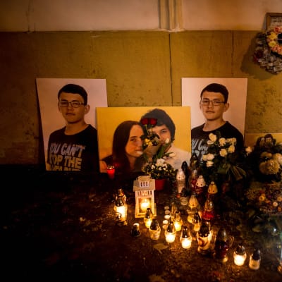 på bilden syns ljus, blommor och fotografier för att hedra journalisten Jan Kuciaks minne.