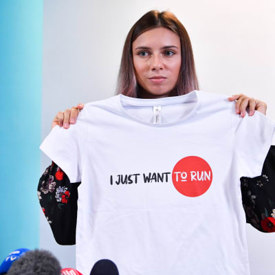Krystsina Tsimanouskaya näyttää T-paitaa jossa lukee "I just want to run".