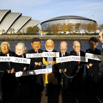 Aktivister har klätt sig i jättehuvuden föreställande världsledare och bär skylten "Climate criminals" framför konferenscentret för FN:s klimatmöte i Glasgow.