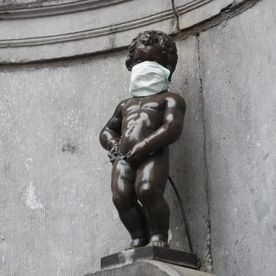 Manneken Pis, statyn som föreställer en liten kissande pojke och som blivit en symbol för Bryssel, har också försetts med ansiktsmask.