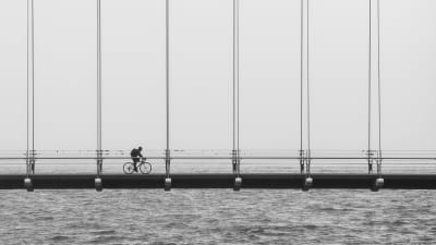 Cyklist cyklar över bro.