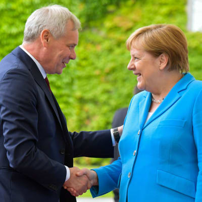 Antti Rinne och Angela Merkel skakar hand.