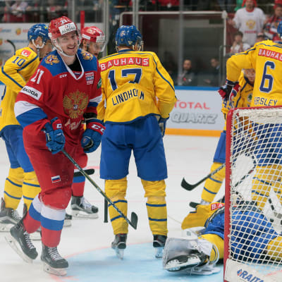 Sergei Kalinin ler mot kameran under ett spelavbrott i matchen Ryssland-Sverige.