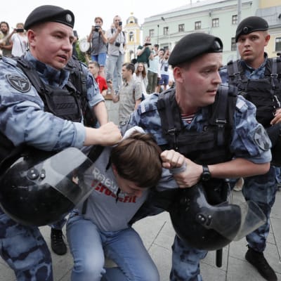 Medlemmar av Rysslands nationalgarde griper demonstranter i Moskva på onsdagen. 