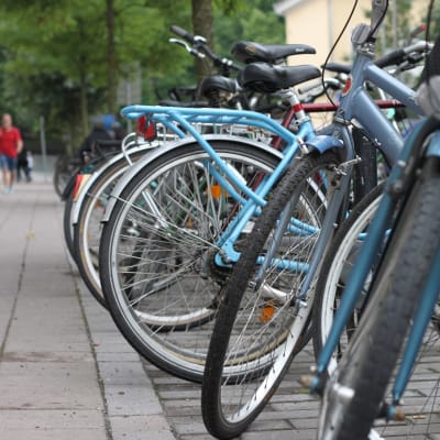 En rad av cyklar parkerade längs en gata.
