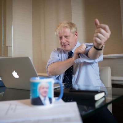Boris Johnson ses kavla upp ärmarna vid en dator. 