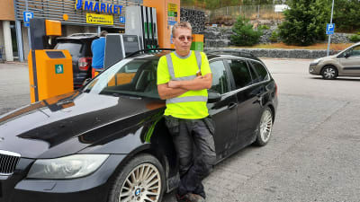 Sture Rask lutar mot sin bil vid bensinstationen i Sibbo.