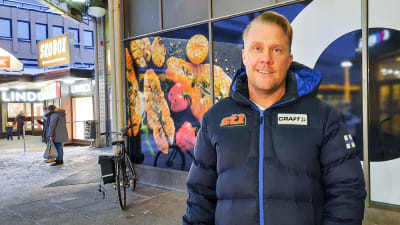 En man i vinterkläder står utanför Citymarket i Borgå. Han ler och tittar mot kameran.