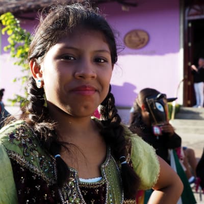 Kvinna tittar in i kamera på latinamerikansk poesikarneval