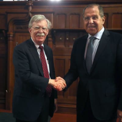 John Bolton och Sergej Lavrov skakar hand.