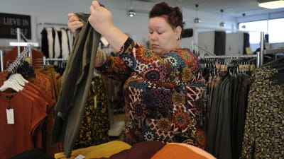 Erica Wickman viker en tröja i sin butik