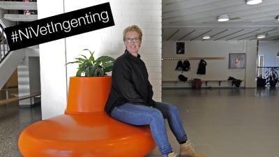 Linda Fagerudd, skolkurator i Pedersöre, sitter  på plastsoffa med #NiVetIngenting i bildens hägra hörn