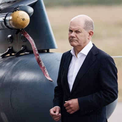 Olaf Scholz seisoo ohjuksen vieressä.