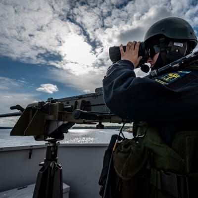 Svensk soldat håller utkik från en båt.