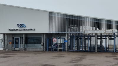 Sininen tehtaan portti. Seinässä lukee "Valmet Automotive".