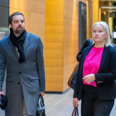 Ville Tapio går i tingsrättens korridor tillsammans med försvarsadvokaten Liina Kokko. 