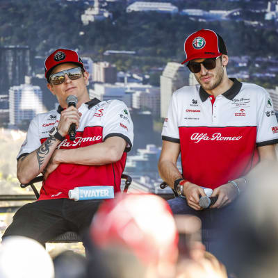 Kimi Räikkönen och Antonio Giovinazzi sitter på en scen.