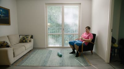 Logged in -dokumenttisarjan päähenkilö Aaron Soivio istuu kotona nojatuolissa.