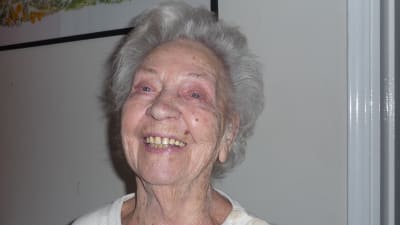 Gunda Lindholm, 100 år, skrattar och ser in i kameran.