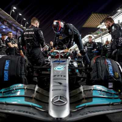 Mercedes-tallin auto ja työntekijöitä F1-kisan varikolla.