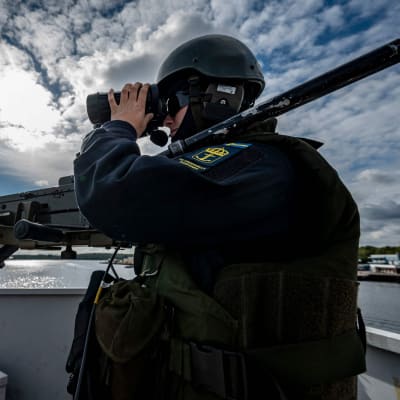 Svensk soldat håller utkik från en båt.