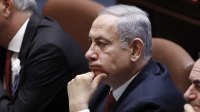 Benjamin Netanyahu sitter med handen mot hakan.