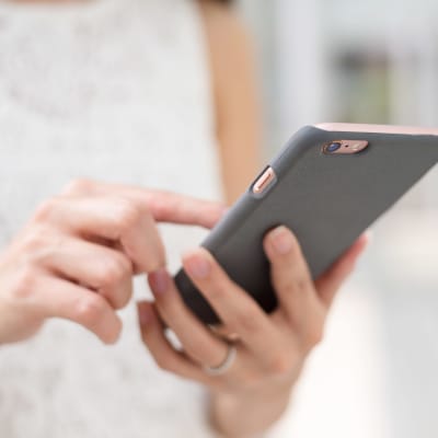 Kvinna petar på mobiltelefon