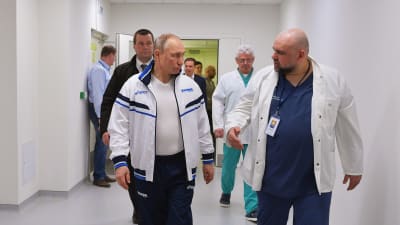 Vladimir Putin går bredvid överläkare Denis Protenko i en korridor i Kommunarka-sjukhuset i Moskva.