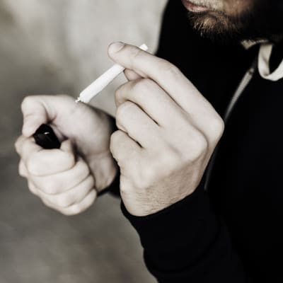Närbild av man som tänder en joint