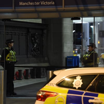 Poliser och en polisbil utanför tågstationen Manchester Victoria efter knivattacken på nyårsafton.