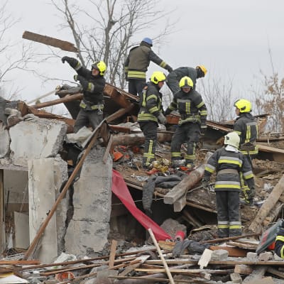 Räddningsarbetare röjer upp i en ruin efter ryska attacker mot Kiev.