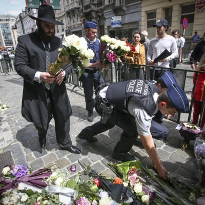 Blommor läggs vid judiska museet i Bryssel där tre personer sköts ihjäl den 24 maj 2014.