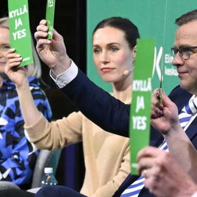 Riikka Purra, Sanna Marin och Petteri Orpo sitter på rad under Helsingin Sanomats valtent.