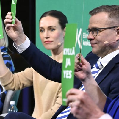 Riikka Purra, Sanna Marin och Petteri Orpo sitter på rad under Helsingin Sanomats valtent.