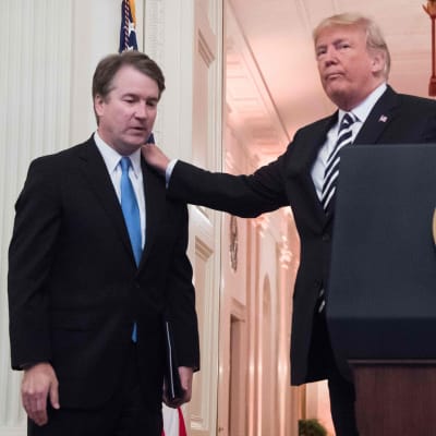 President Trumps hand ser ut att tynga domare Kavanaughs axel.