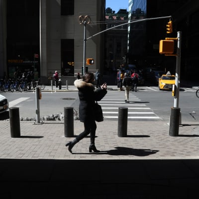 Fotgängare går förbi säkerhetshinder på en trottoar på Wall street, New York.