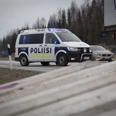 Poliisiauto vahtii liikennettä kun rakennusmiehet asentavat betoniporsaita Valtatie 3. tiesululle  27.3.2020.