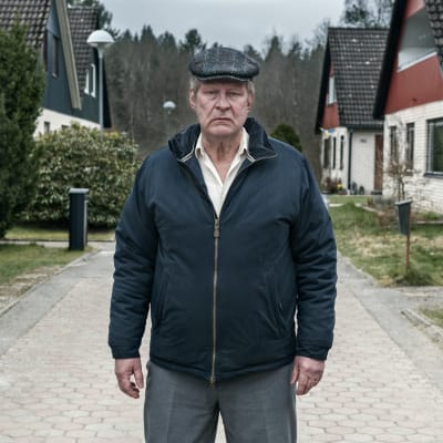 Rolf Lassgård poserar på gata i villaområde