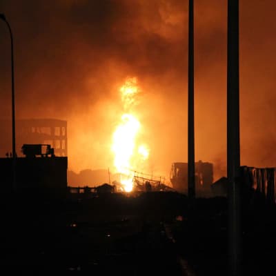 Flammor efter explosionen i Tianjin, Kina.