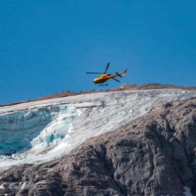 Pelastushelikopteri Marmolada-vuoren jäätikön yllä.
