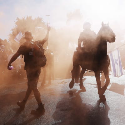 Protester i Israel. Demonstranter i rök, en häst och säkerhetsstyrkor.