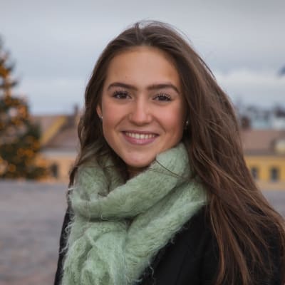 Porträttbild på Finlands lucia framför en julgran.
