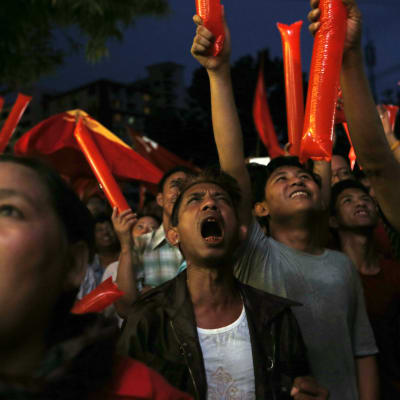 NLD-anhängare utanför partiets huvudkontor gläder sig över de första resultaten i Burmas parlamentsval.