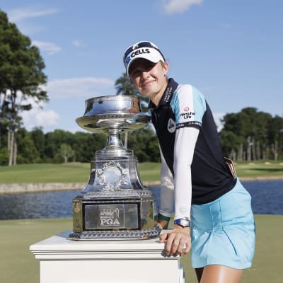 Nelly Korda poseeraa voittopystin kanssa. 