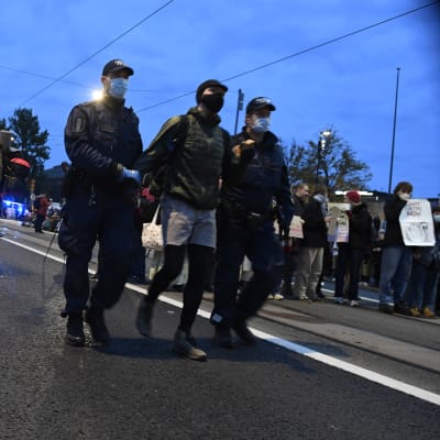 Poliisit siirtävät bussiin Syyskapina-mielenosoituksesta kiinniotettua ympäristöliike Elokapinan mielenosoittajaa eduskuntatalon edustalla Mannerheimintiellä.