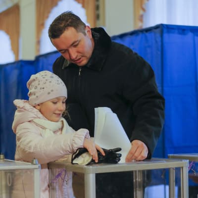 En ukrainsk man röstar tillsammans med ett barn i Kiev den 26 oktober 2014.