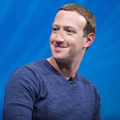 Mark Zuckerberg ler och tittar åt sidan.